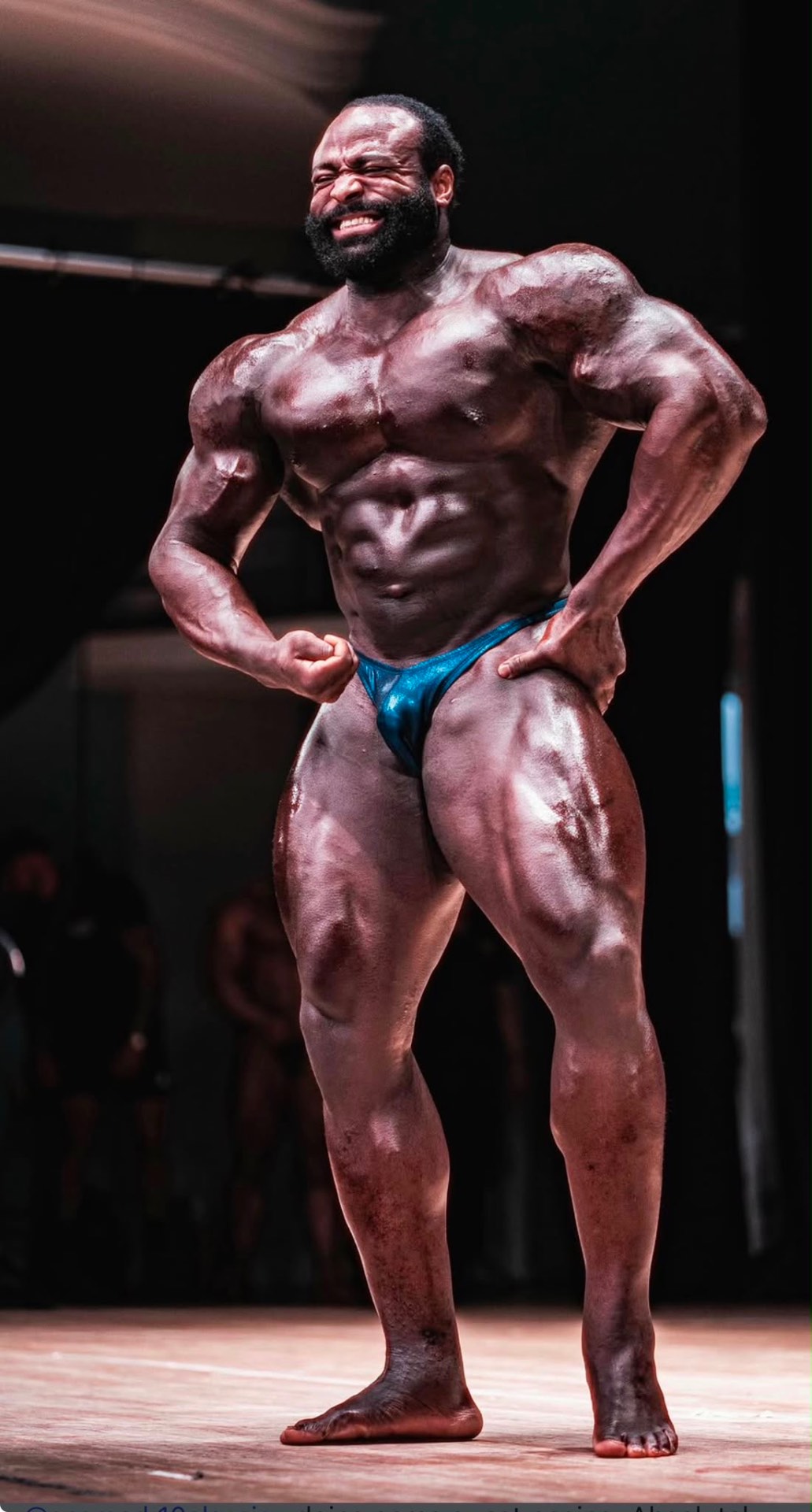 Bodybuilder side chest pose — stage