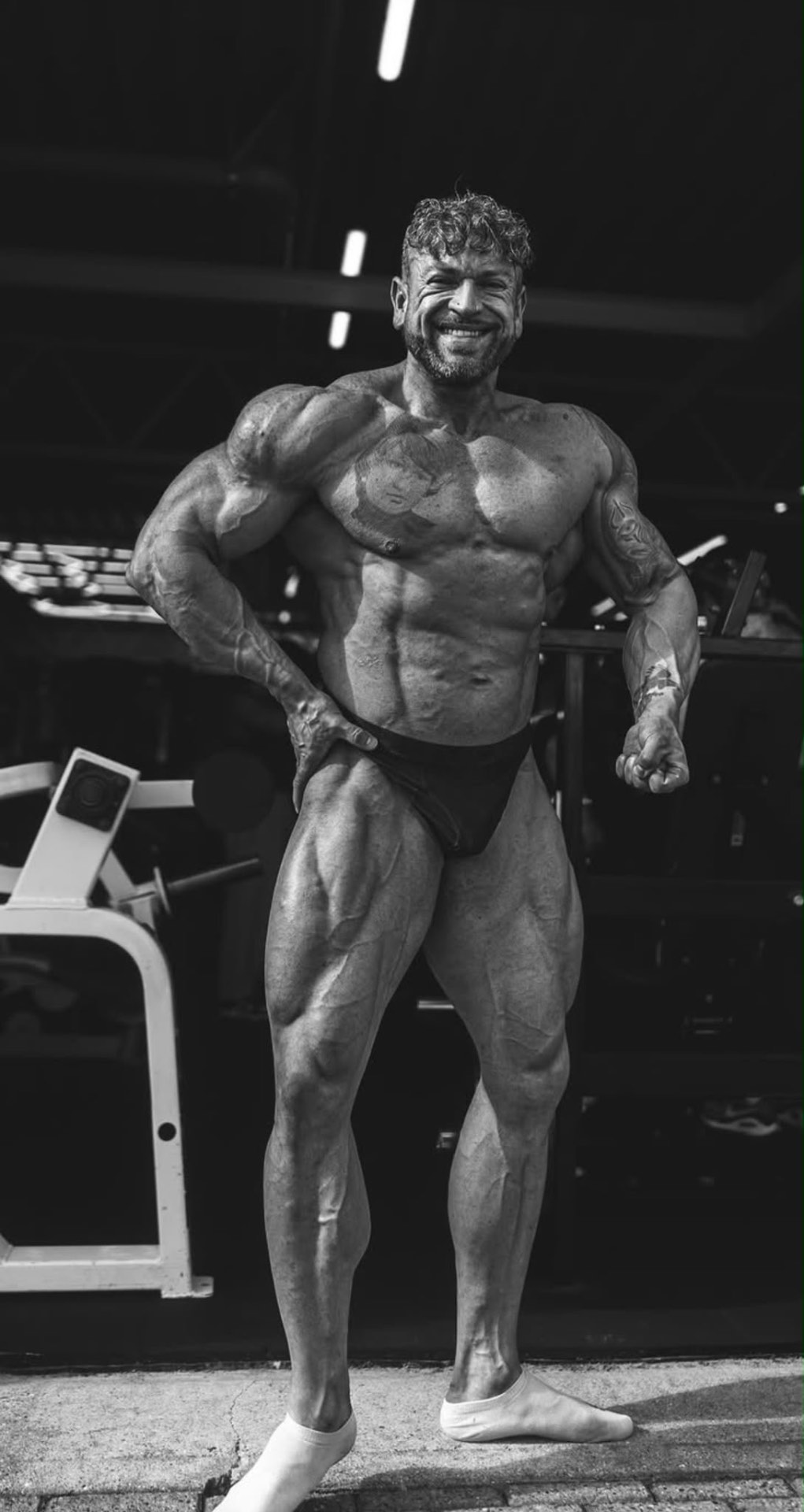 Bodybuilder side chest pose — black & white