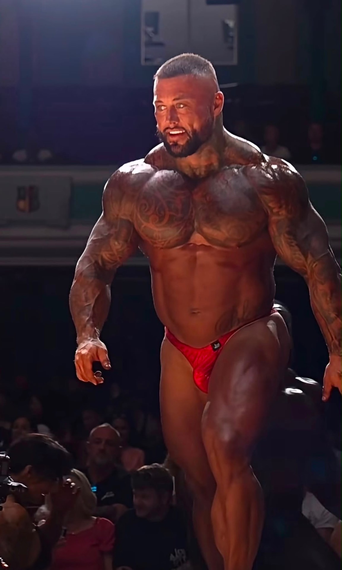 Bodybuilder stage walk — red trunks